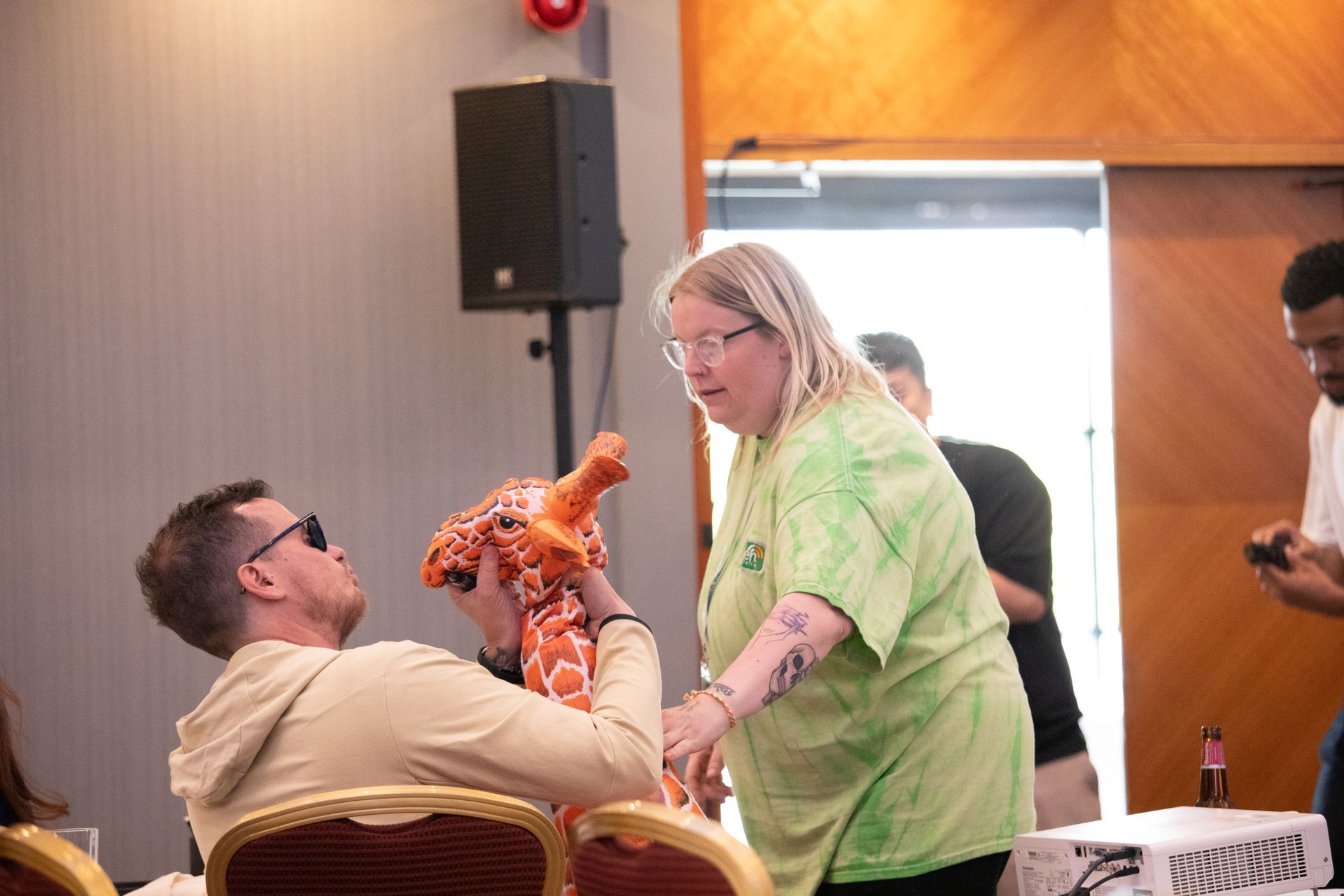 A woman is holding a stuffed animal next to a man in a room.