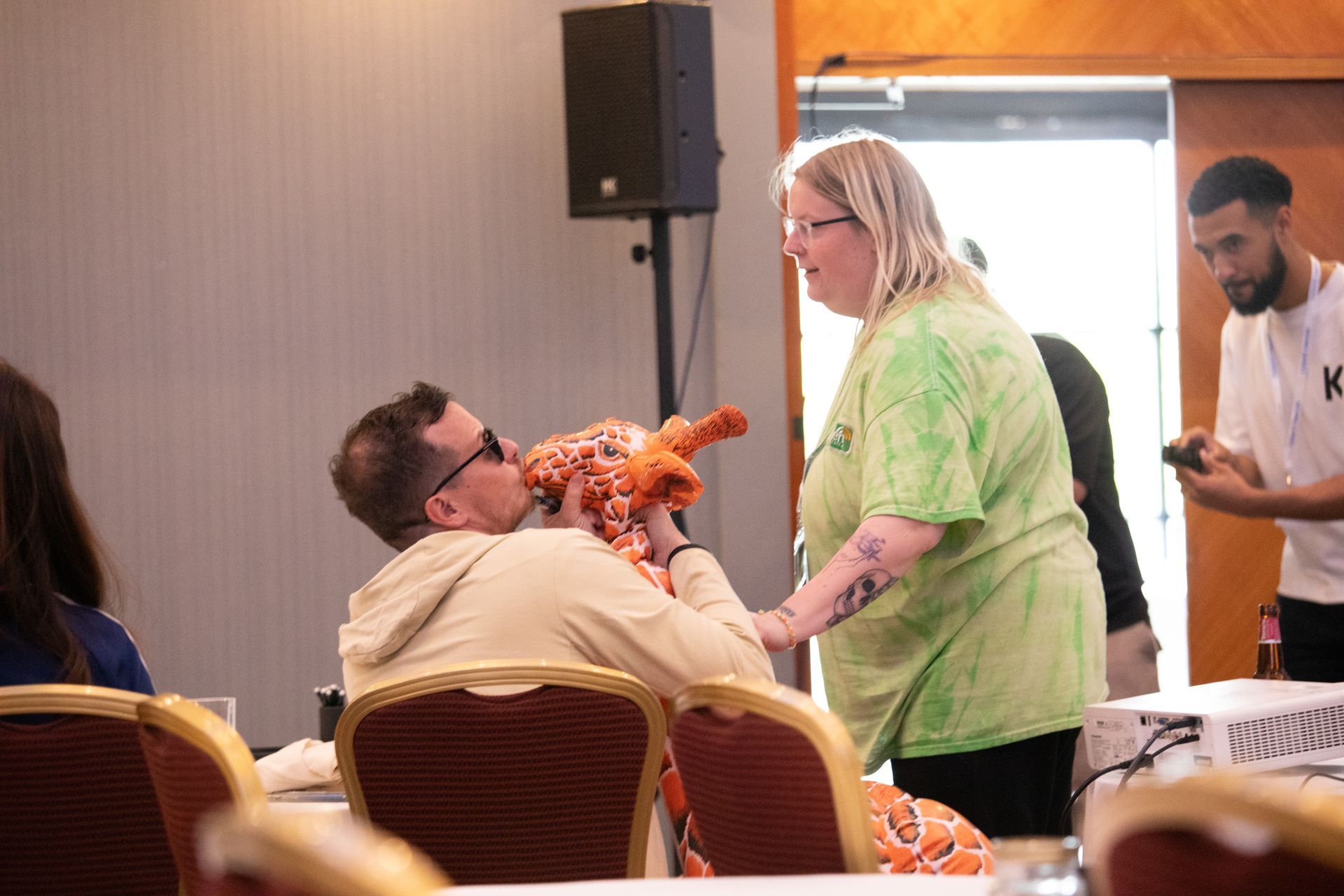 A man and a woman are sitting at a table holding a stuffed animal.
