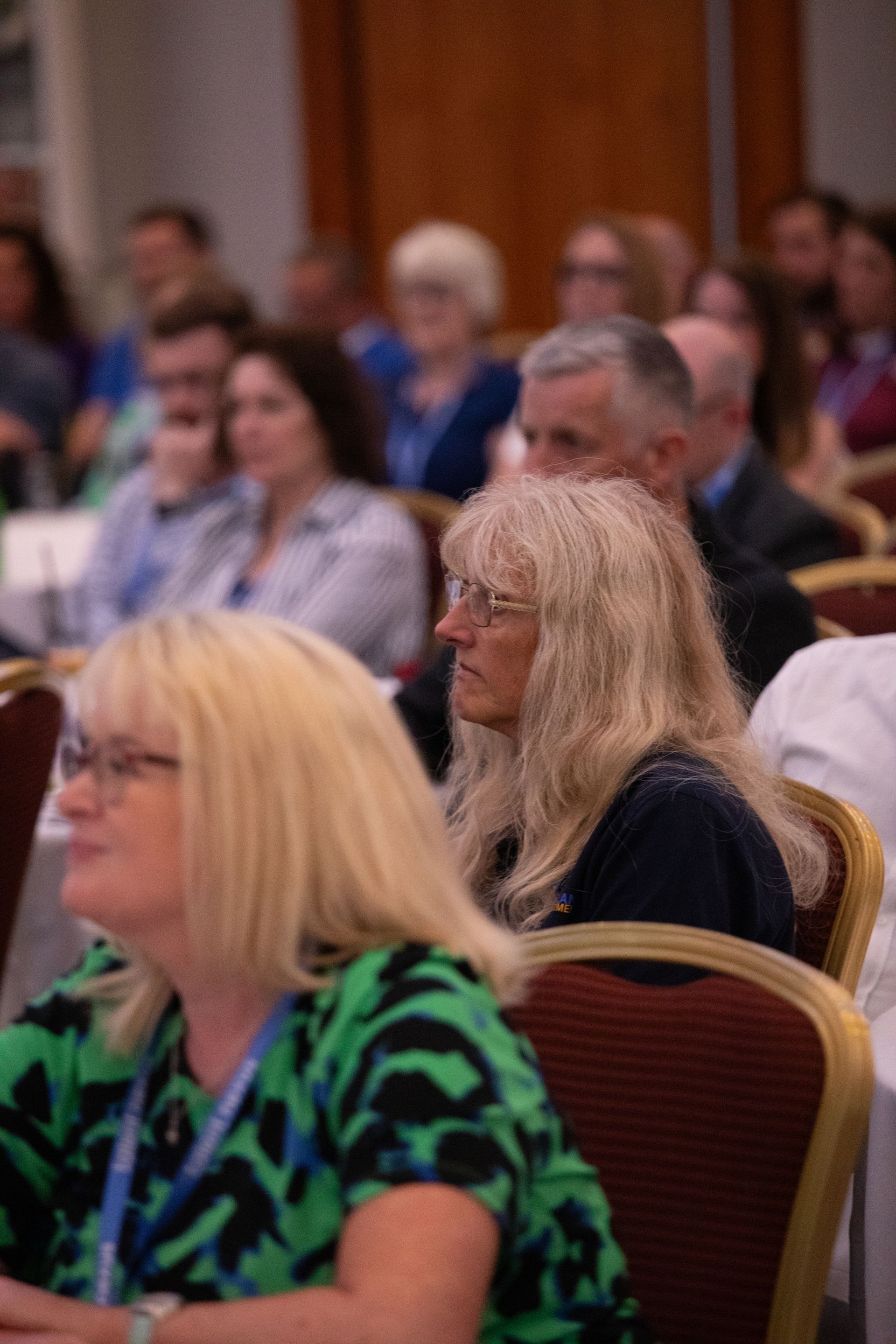 A group of people are sitting in chairs at a conference.