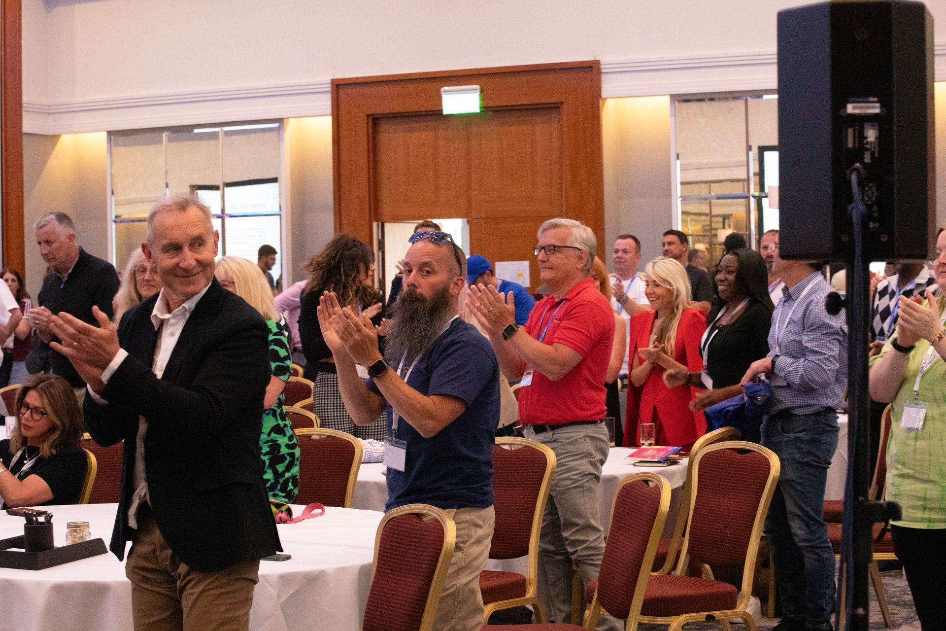 A group of people are clapping in a room.