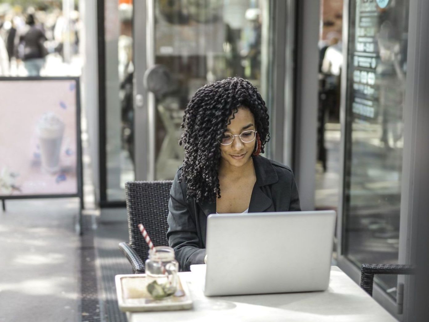 A woman is sitting at a table using a laptop computer.