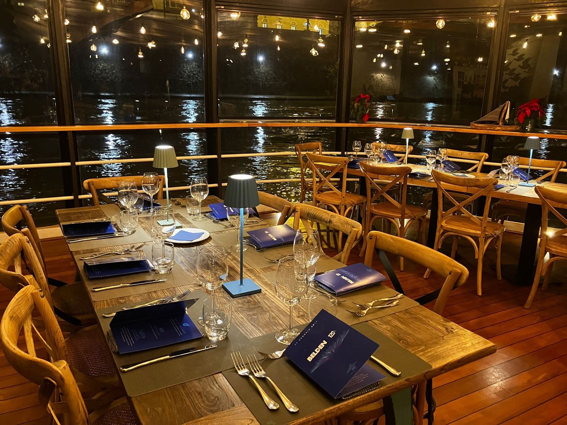 Un gruppo di barche è attraccato lungo un fiume di notte.