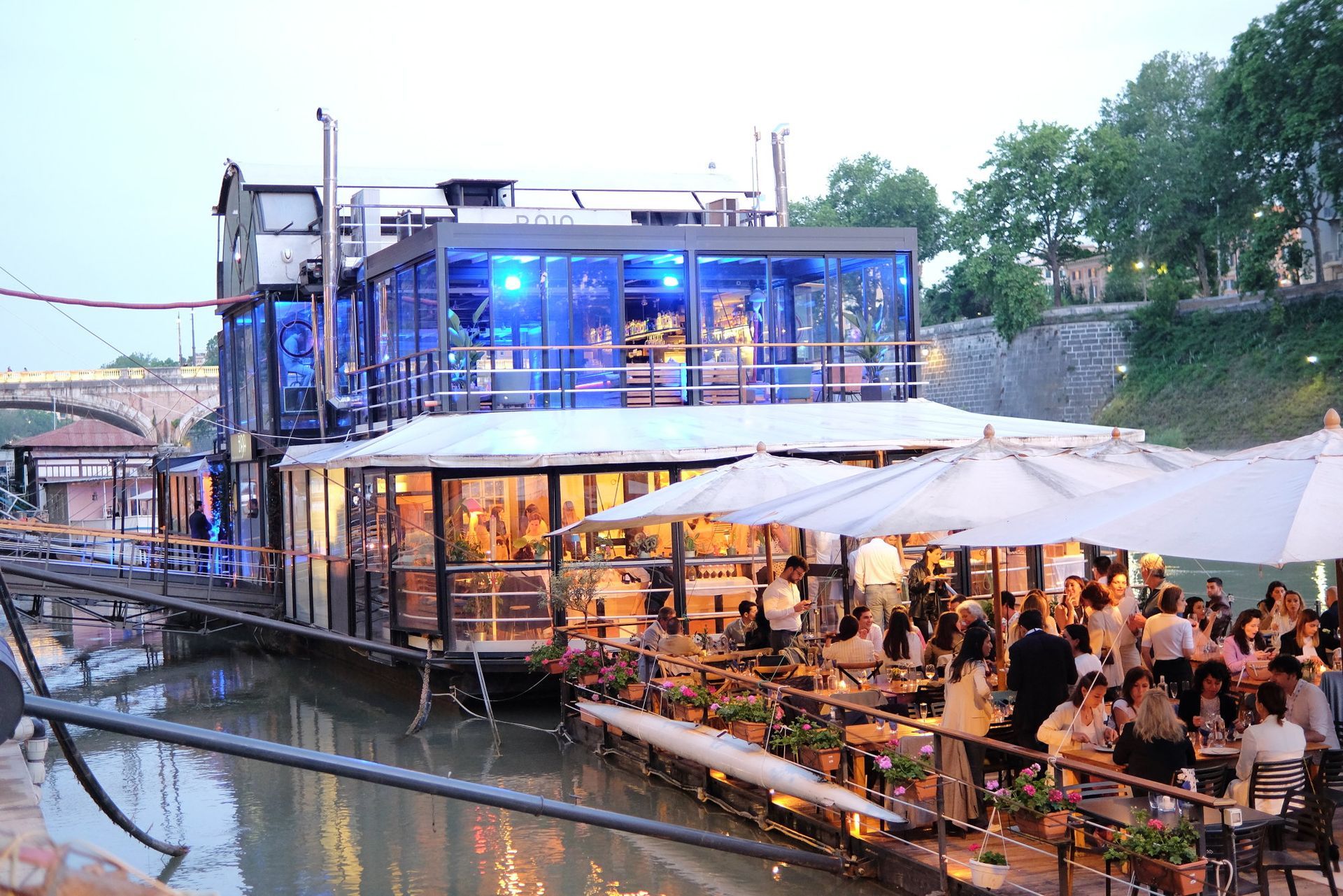 Un gruppo di persone è seduto fuori da un ristorante su una barca.