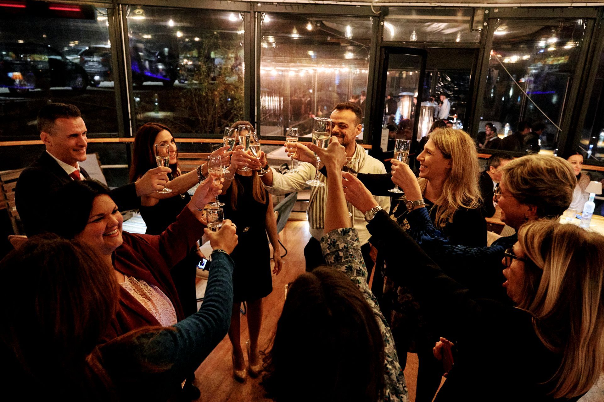 Un gruppo di persone sta brindando con bicchieri di champagne in una stanza.