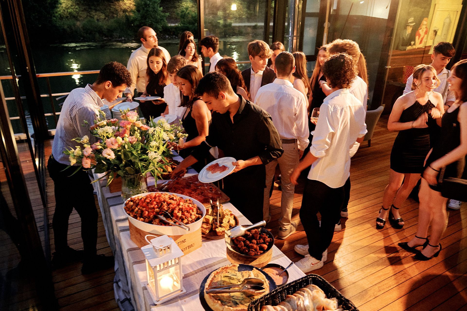 Un gruppo di persone è in piedi attorno a un tavolo da buffet.