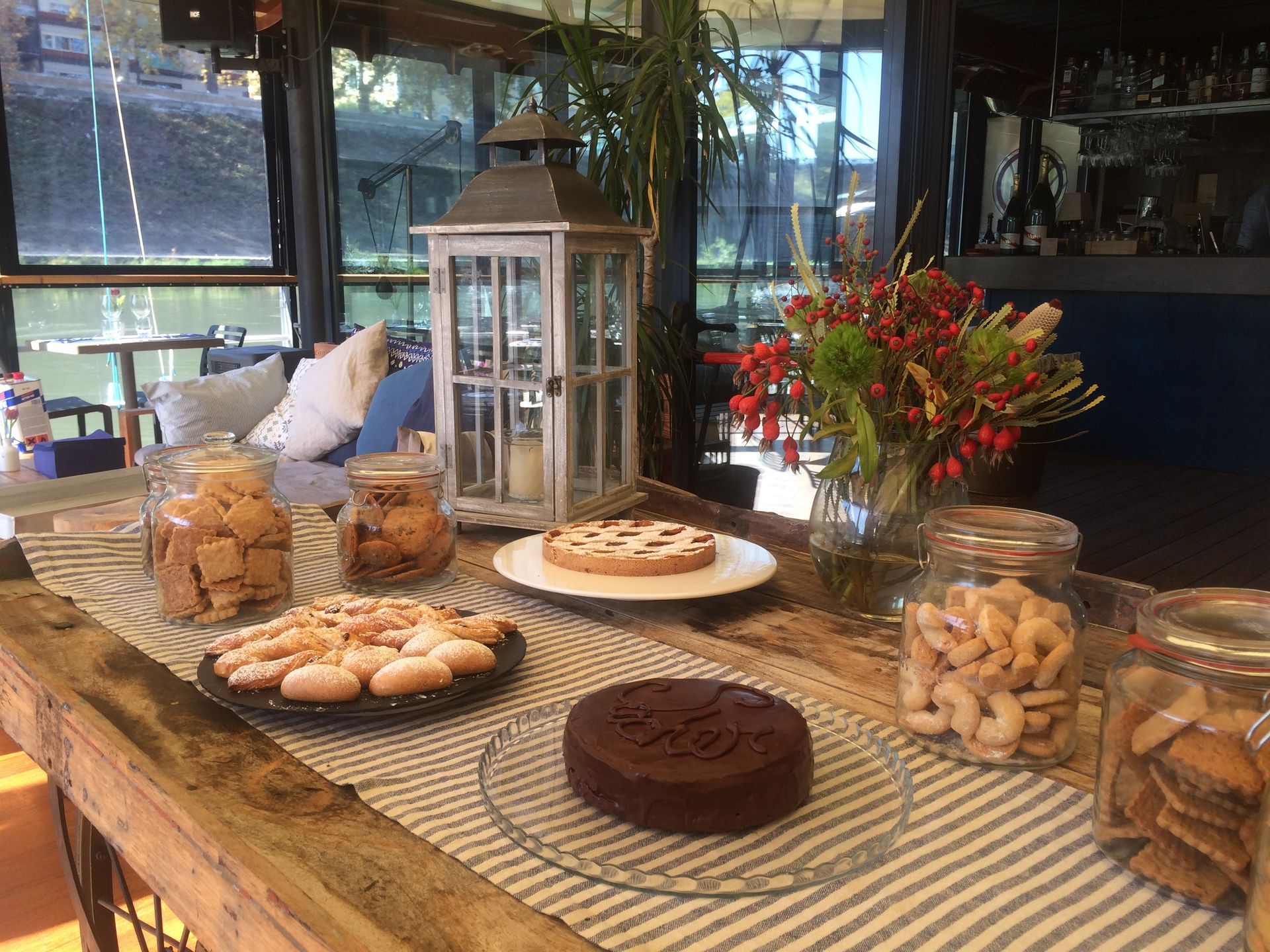 Un tavolo di legno sormontato da piatti di cibo e barattoli di noci.