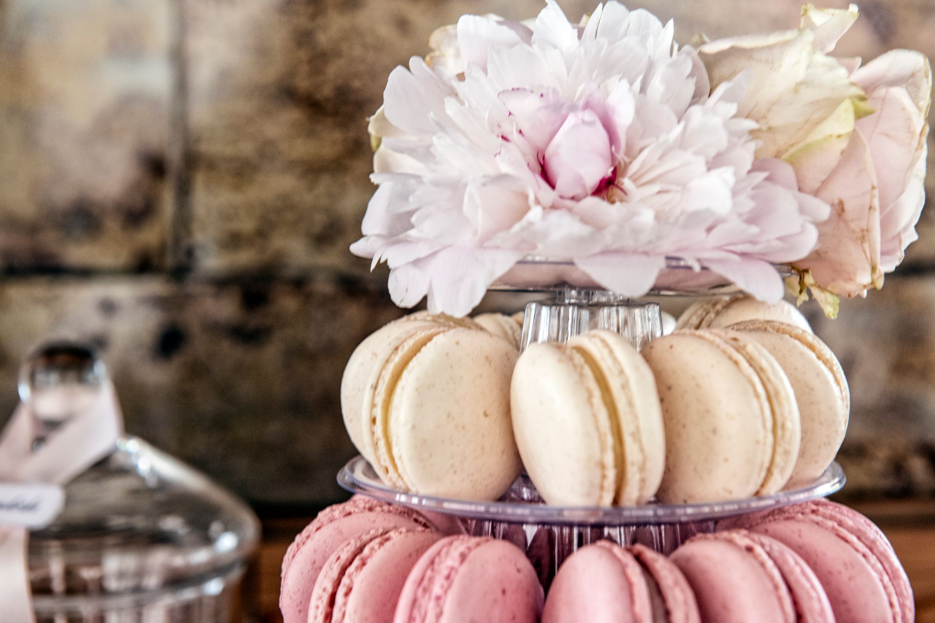 Una pila di macaron rosa con fiori sopra.