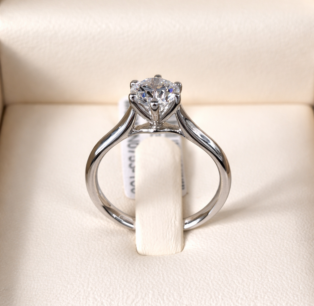 Anello di fidanzamento con diamante, con una grande pietra centrale quadrata e una fascia curva incastonata con diamanti più piccoli.