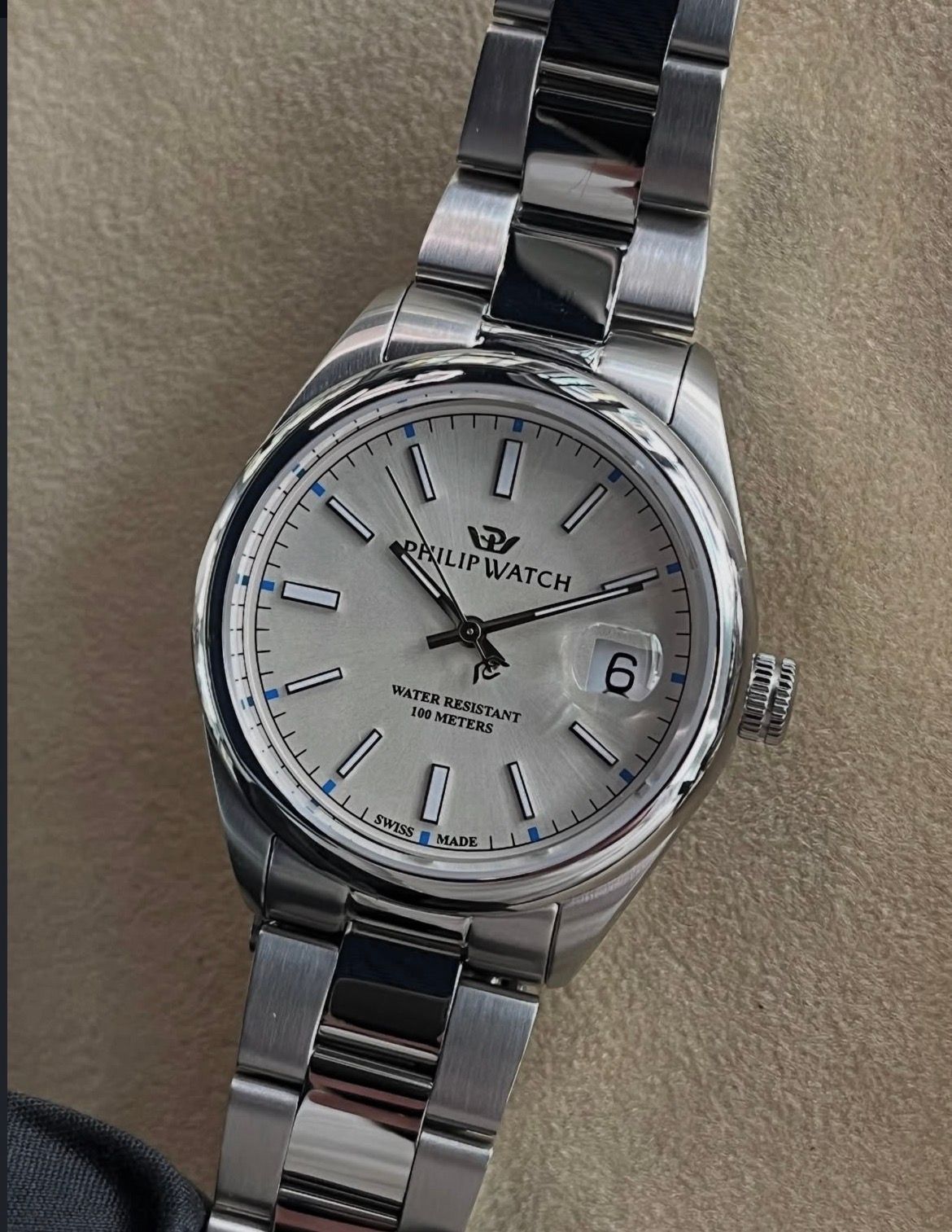 Primo piano di un orologio automatico Sector in argento con quadrante nero, lunetta blu e numeri bianchi.