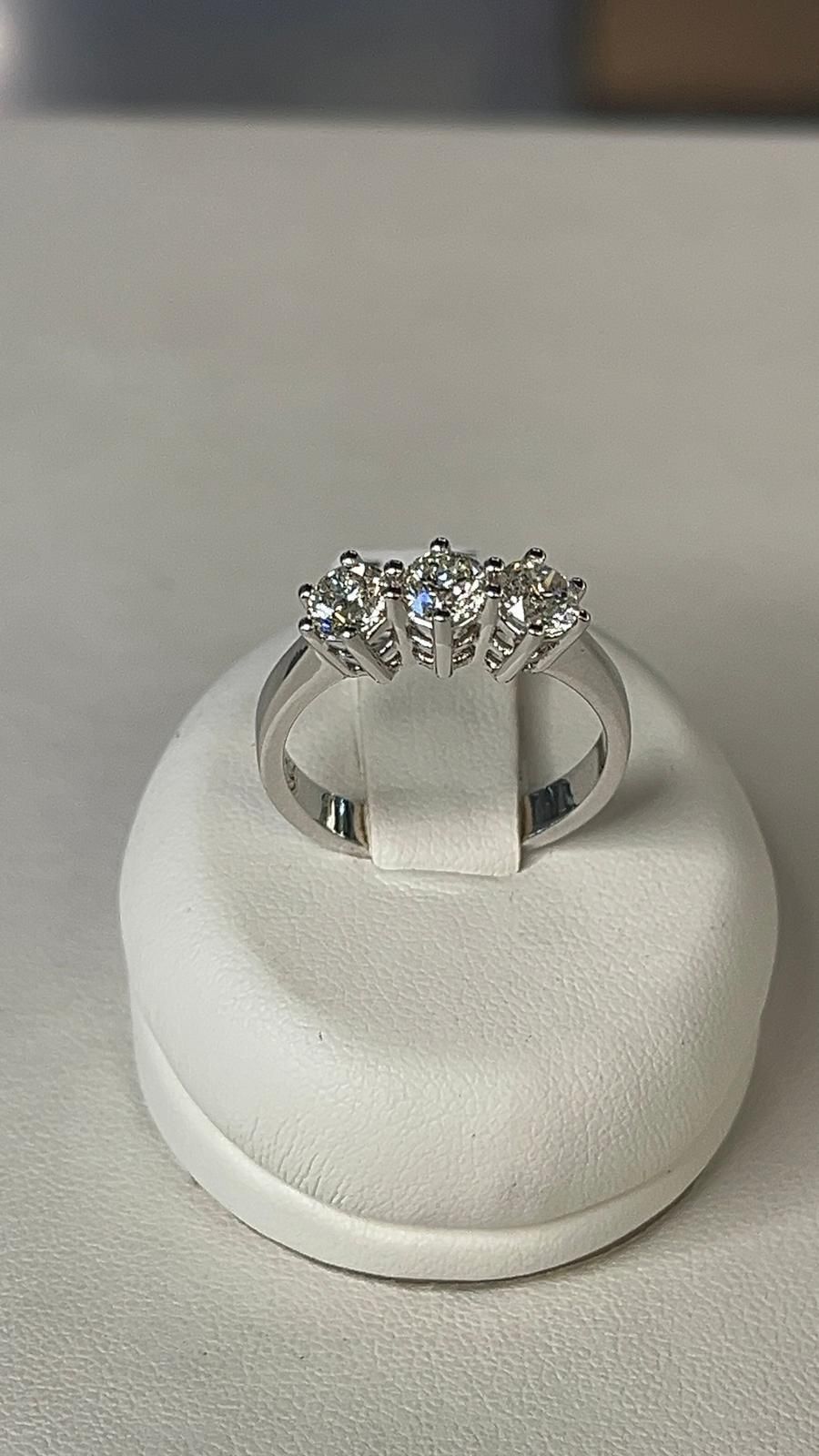 Anello in argento con cinque pietre preziose trasparenti su supporto bianco.