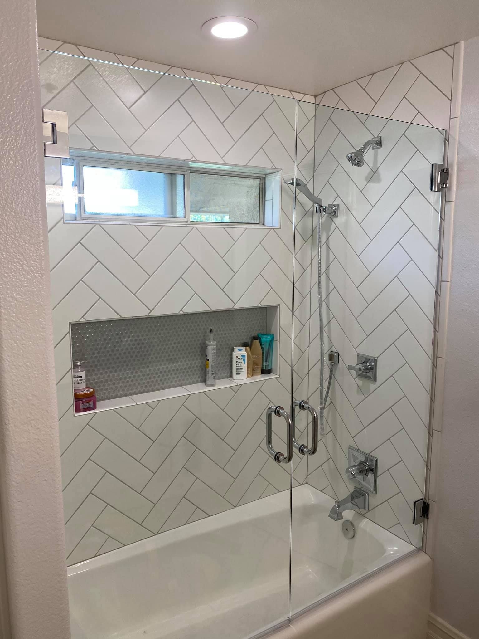 A bathroom with a bathtub and a shower with a glass door