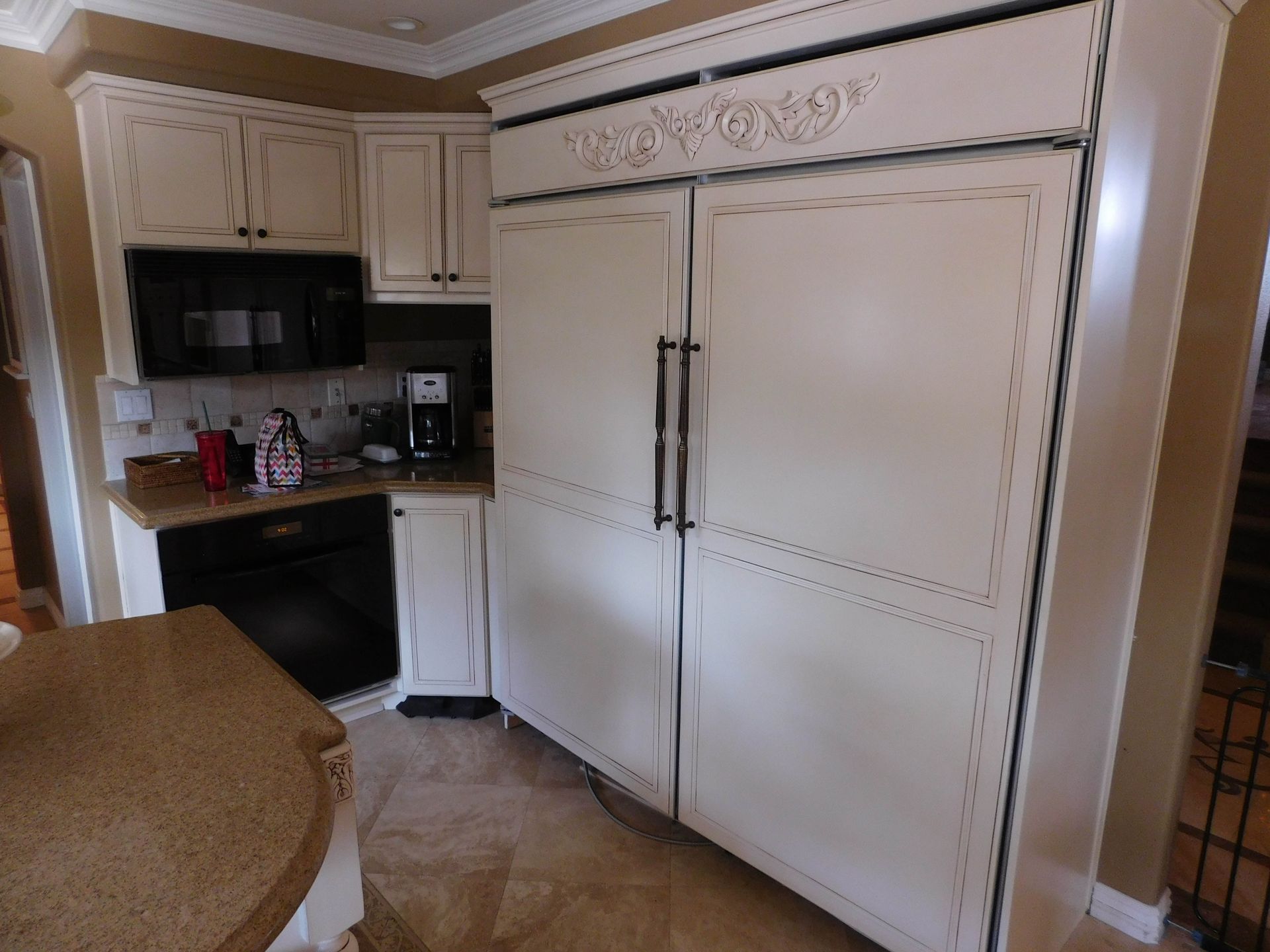 A kitchen with white cabinets and black appliances