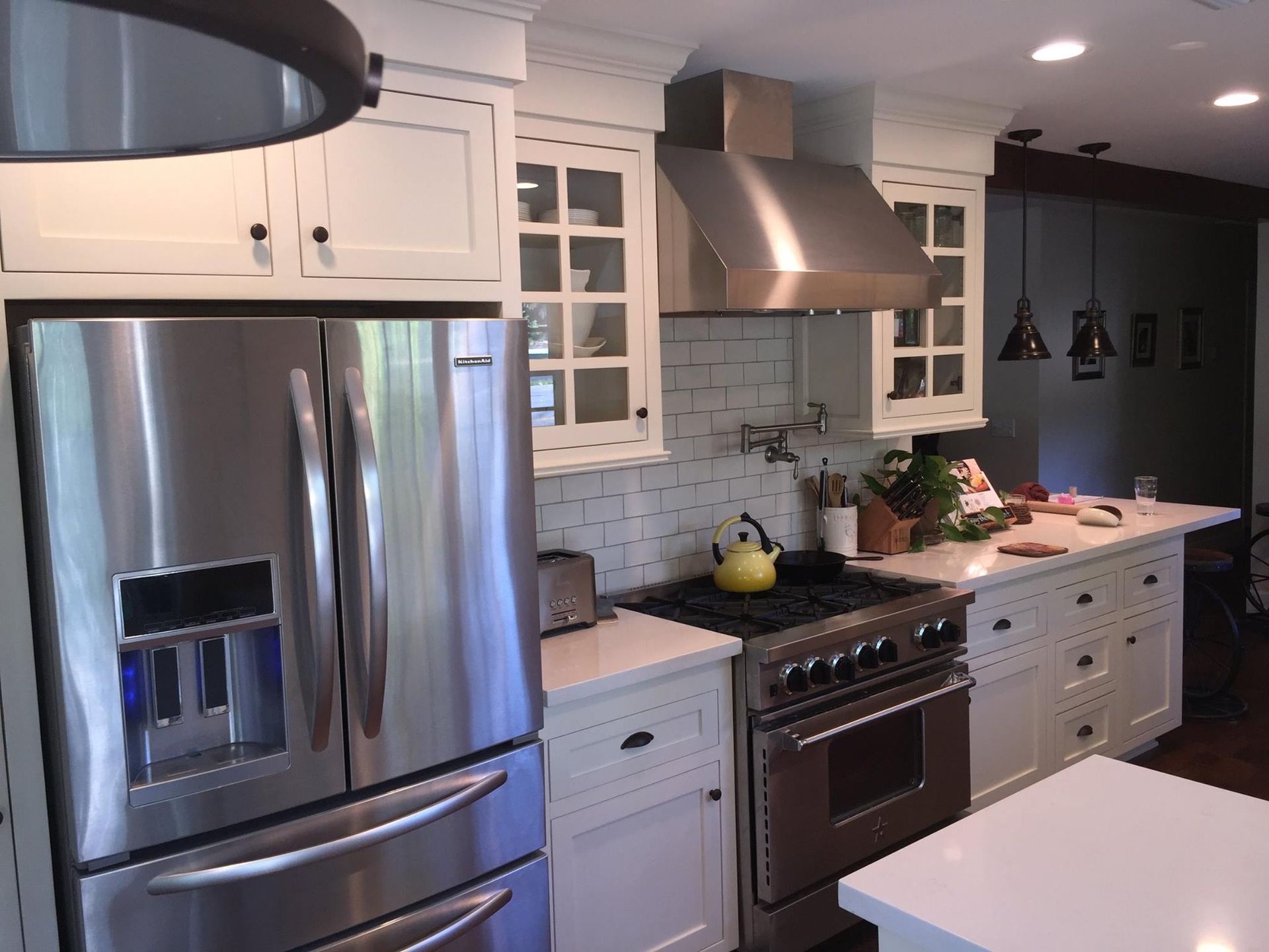 A kitchen with stainless steel appliances and white cabinets
