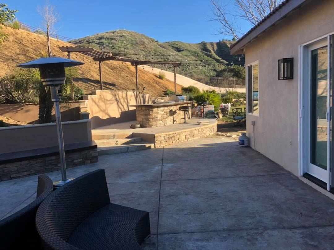 A patio with a chair and a heater in front of a house