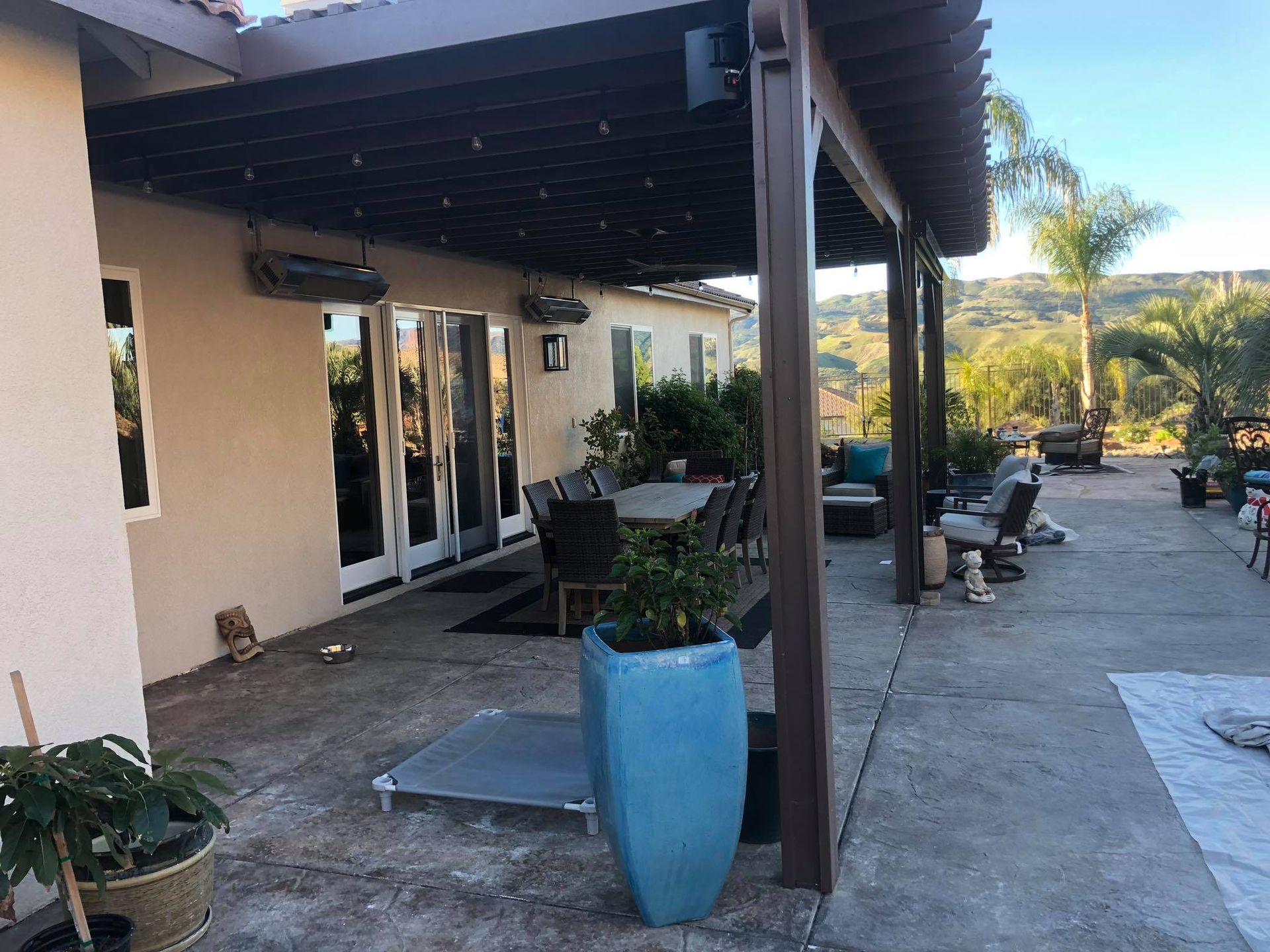 A patio with a table and chairs and a blue potted plant