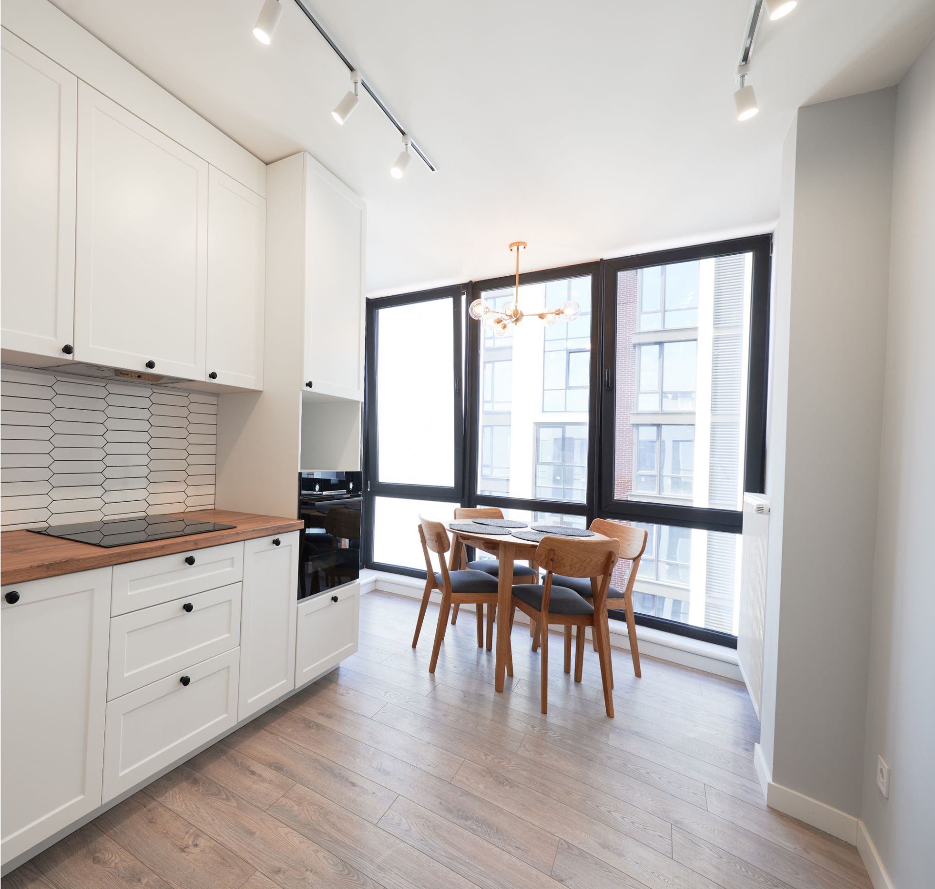 A kitchen with white cabinets and a table and chairs
