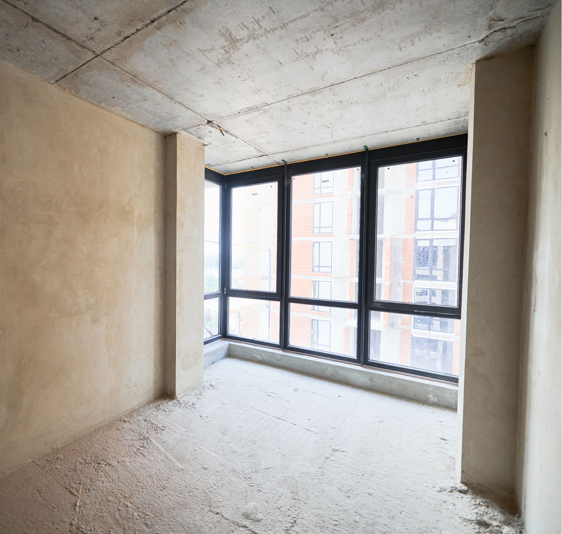 An empty room with a lot of windows and a concrete ceiling