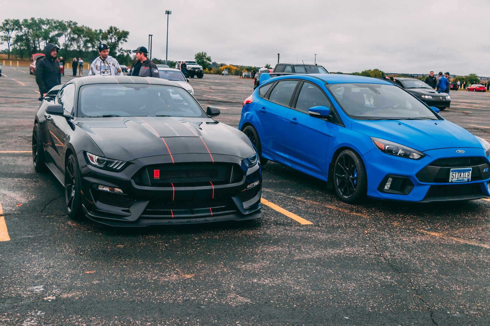 grey sport car and blue sedan car side by side in parking lot