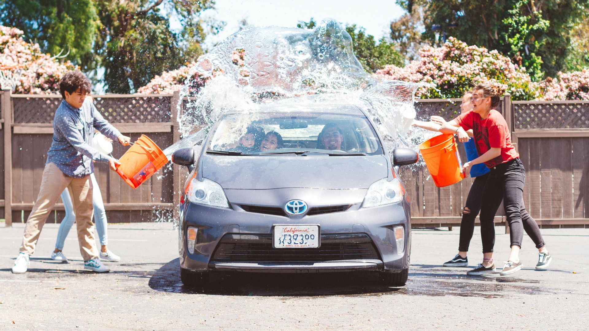 four kids washing a sedan.