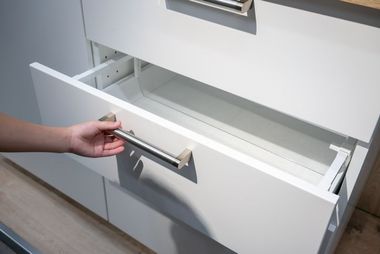 Woman hand pulling a drawer organized with additional plastic inside