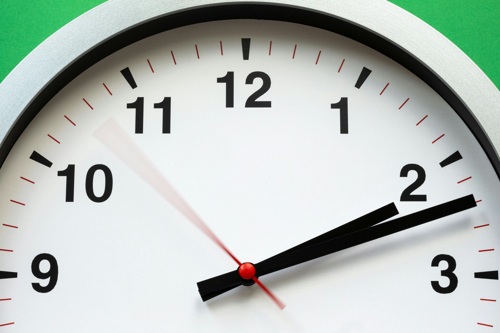 Clock showing the time as ten minutes past two; white face, black hands, red second hand.