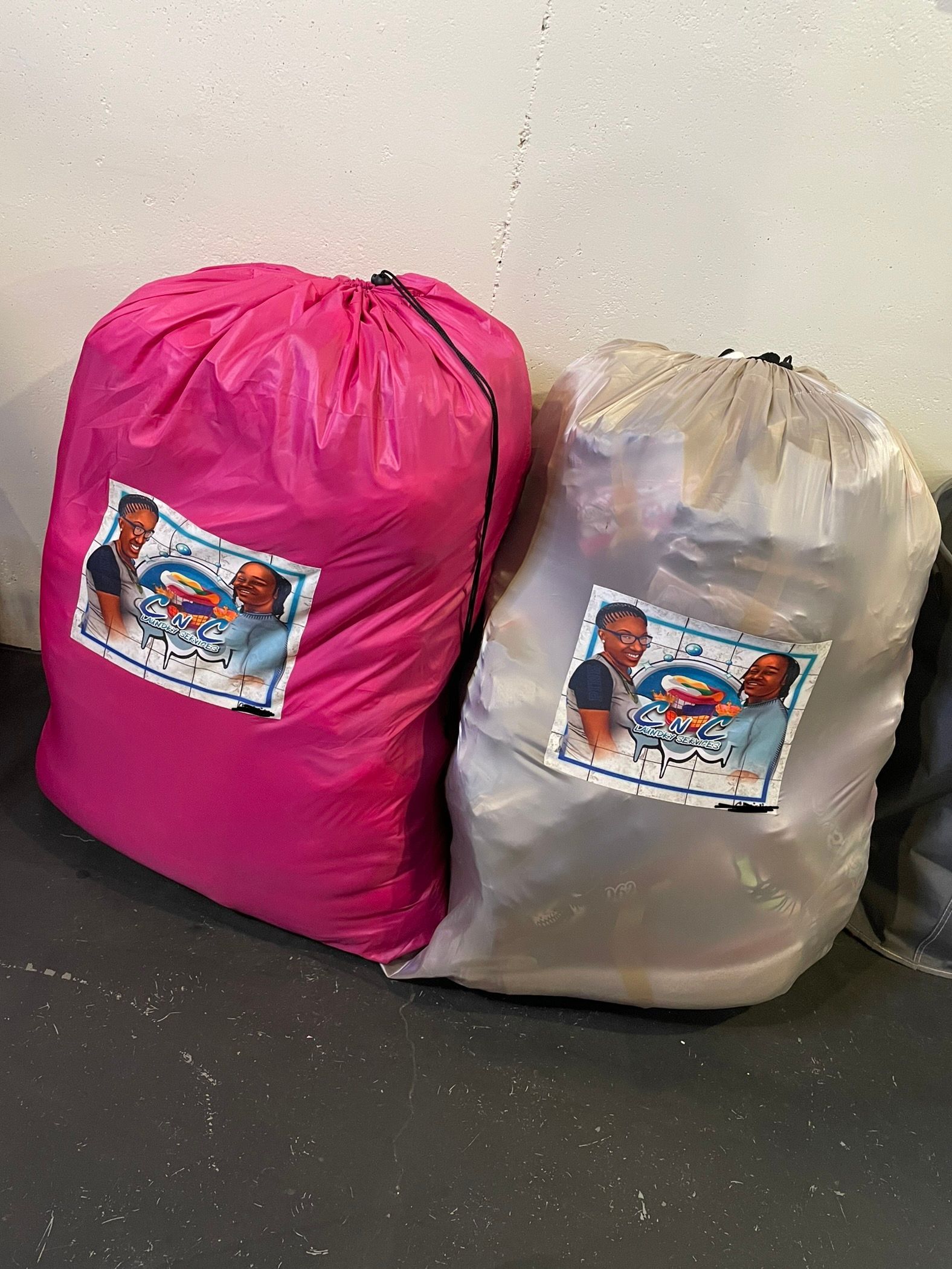 Two laundry bags are sitting next to each other on the floor.