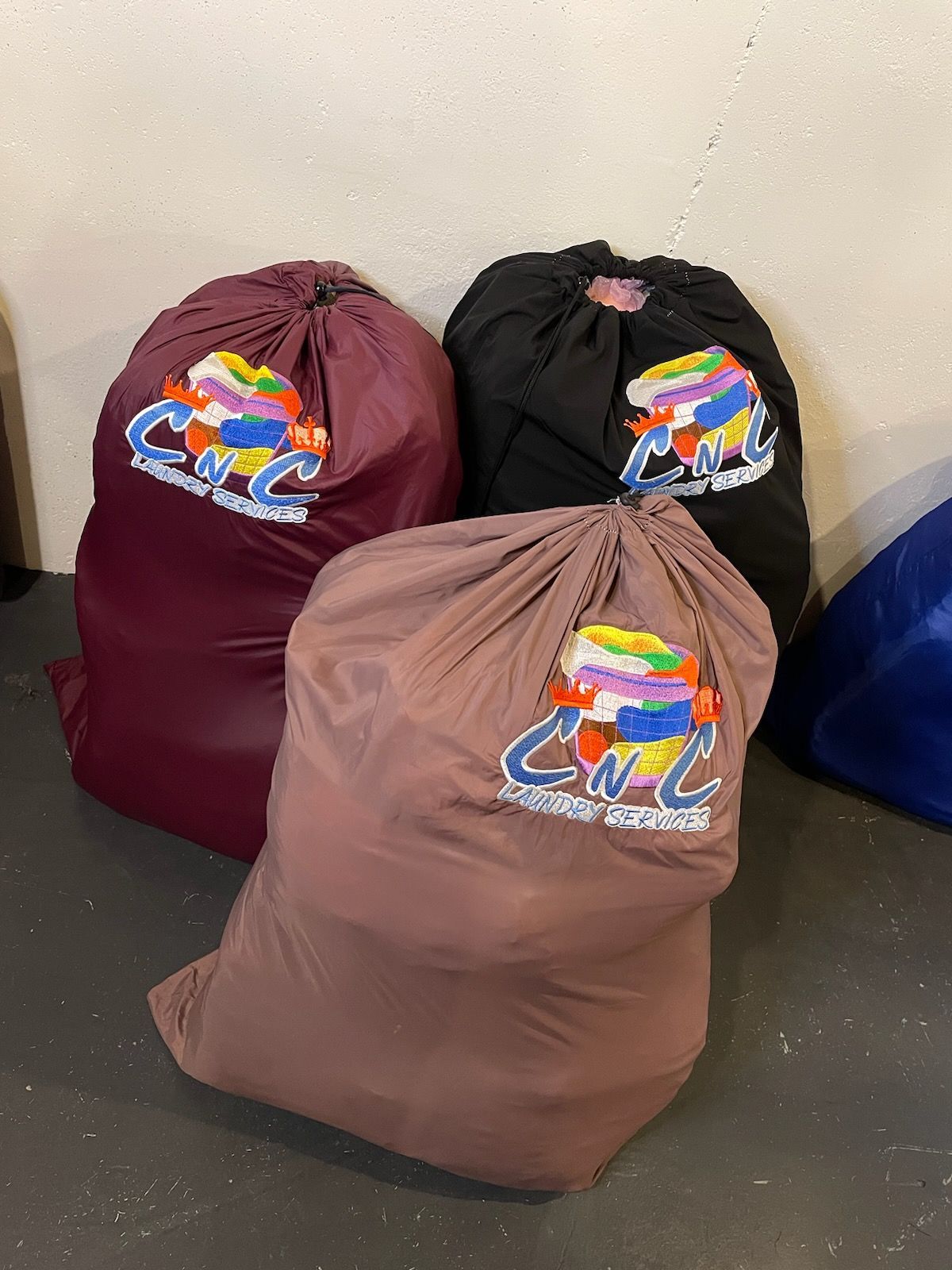 Three bags with the letters cc on them are sitting on the floor
