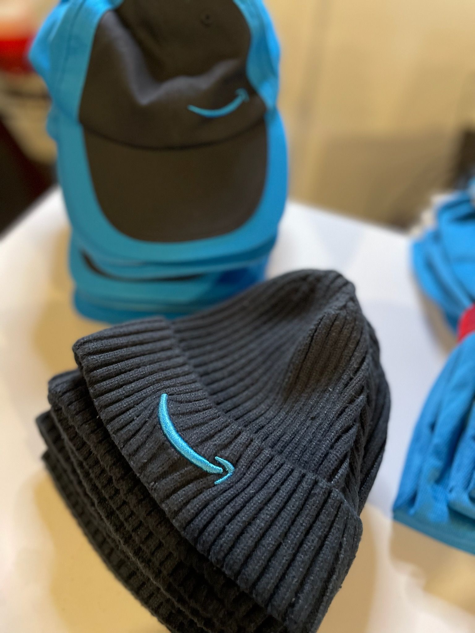 A stack of amazon hats are sitting on a table