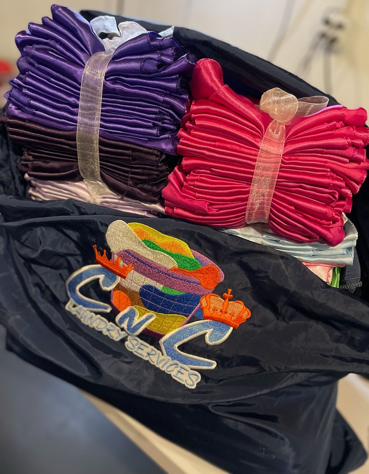 A black bag filled with a bunch of clothes and a cnc logo