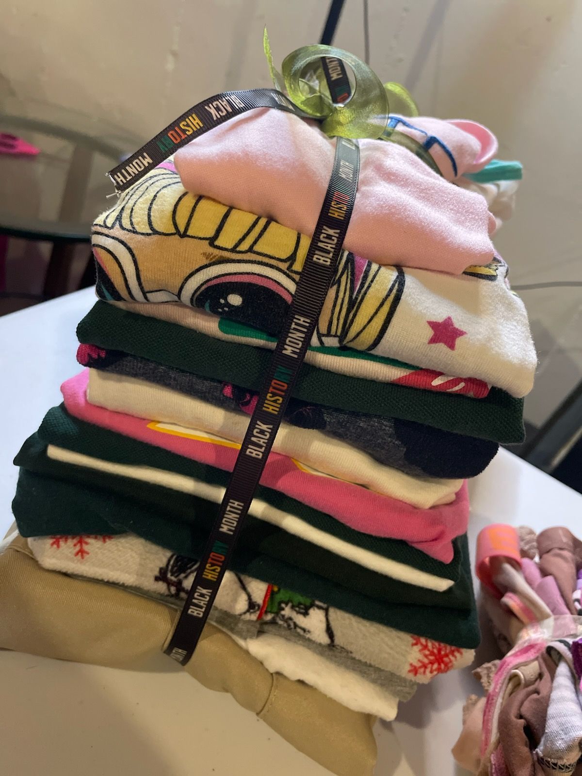Stack of colorful children's socks tied with a black ribbon, and a small bundle of socks beside it.