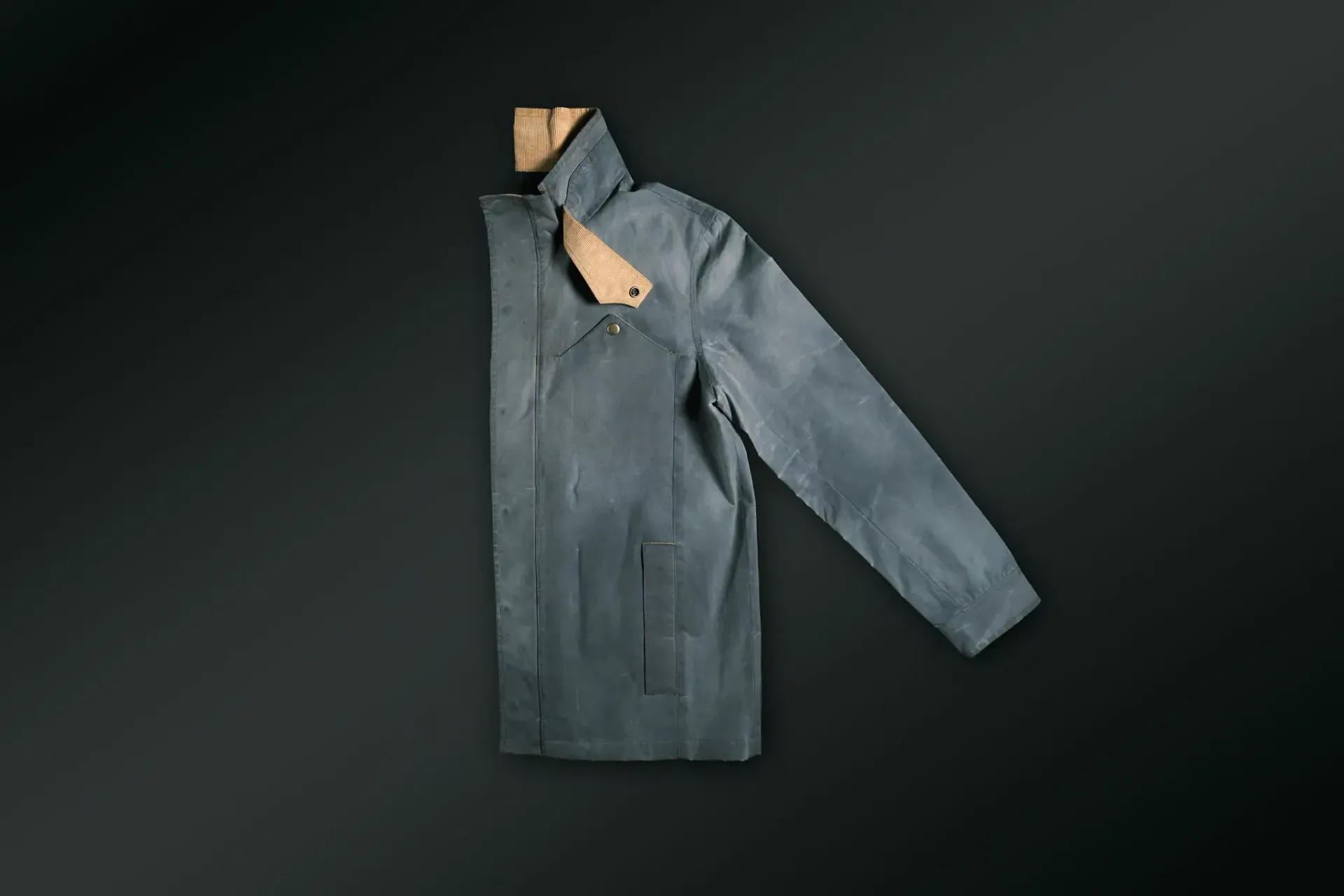A blue jacket is hanging on a hanger on a black background