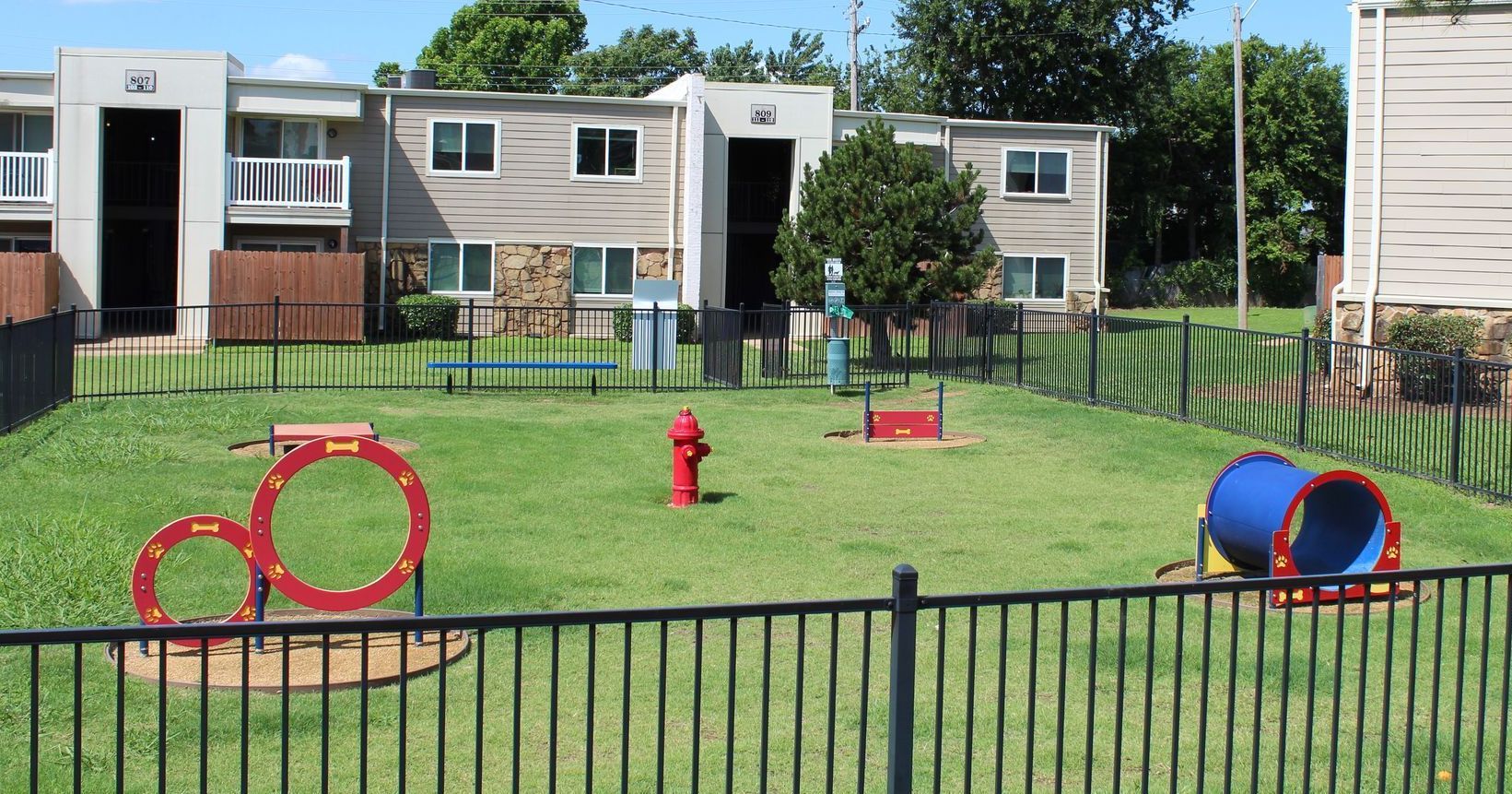A dog park with a fire hydrant in the middle of it