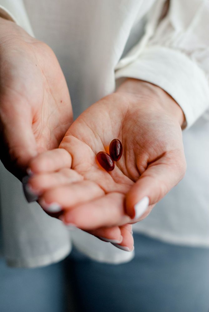 Eine Frau hält zwei Pillen in der Hand.