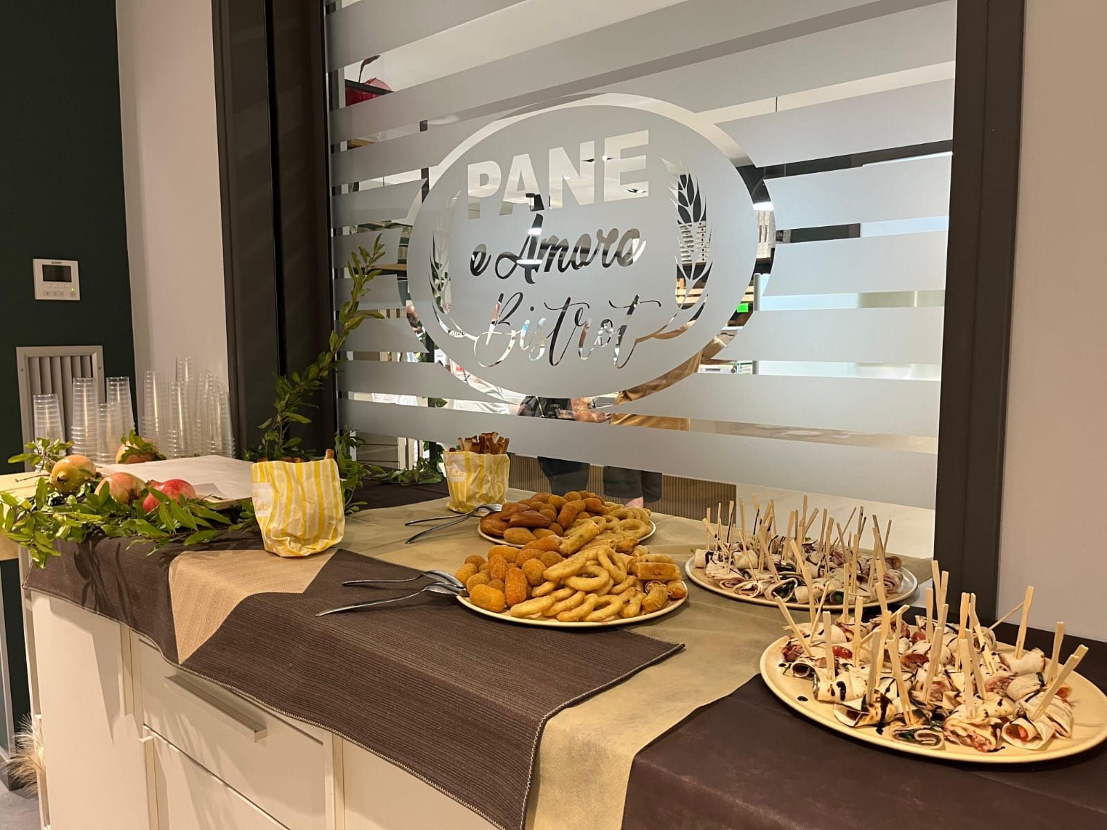 Tavolo da buffet con antipasti davanti a una finestra con la scritta