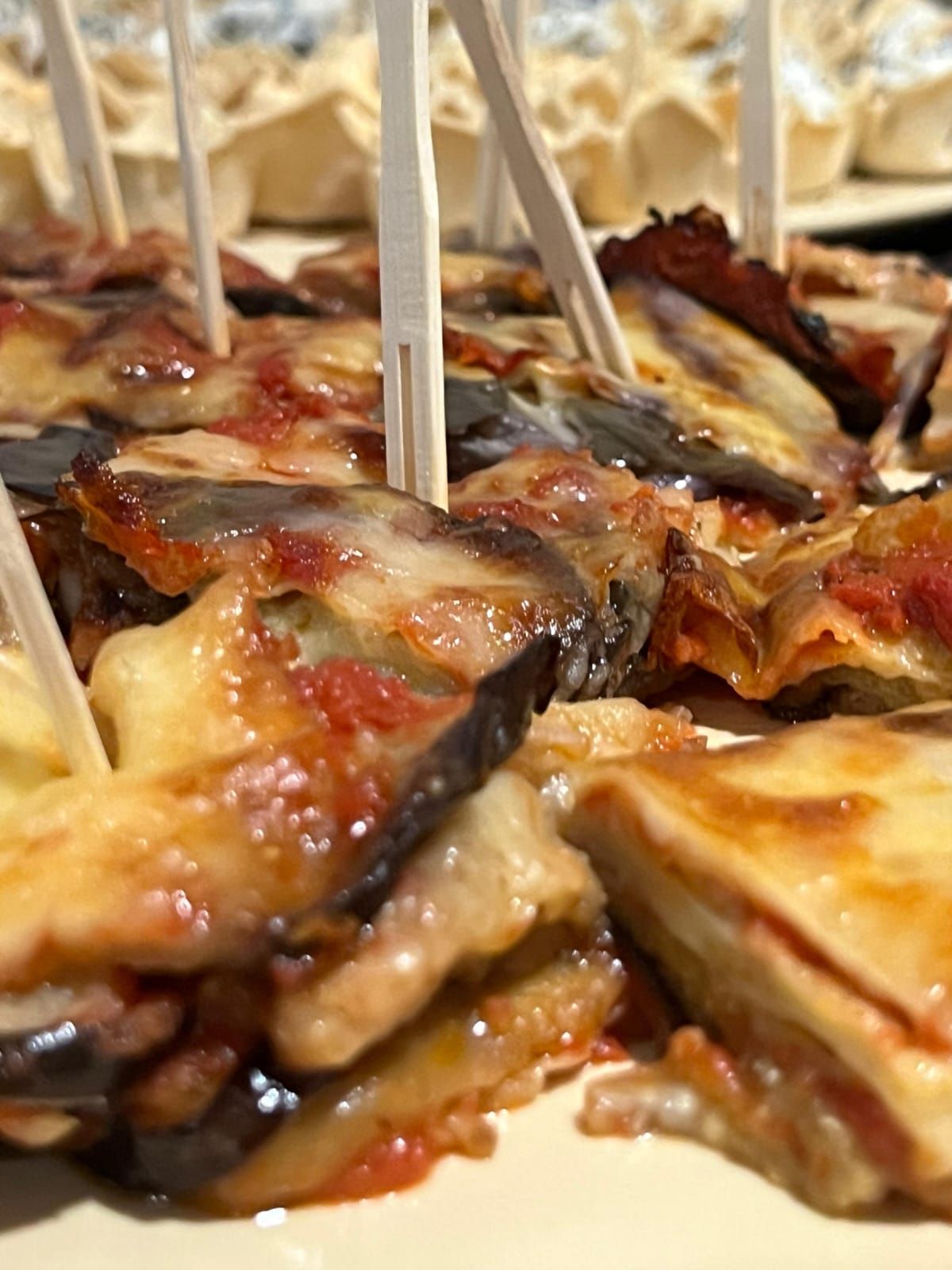 Fette di melanzane con formaggio, salsa di pomodoro e stuzzicadenti.