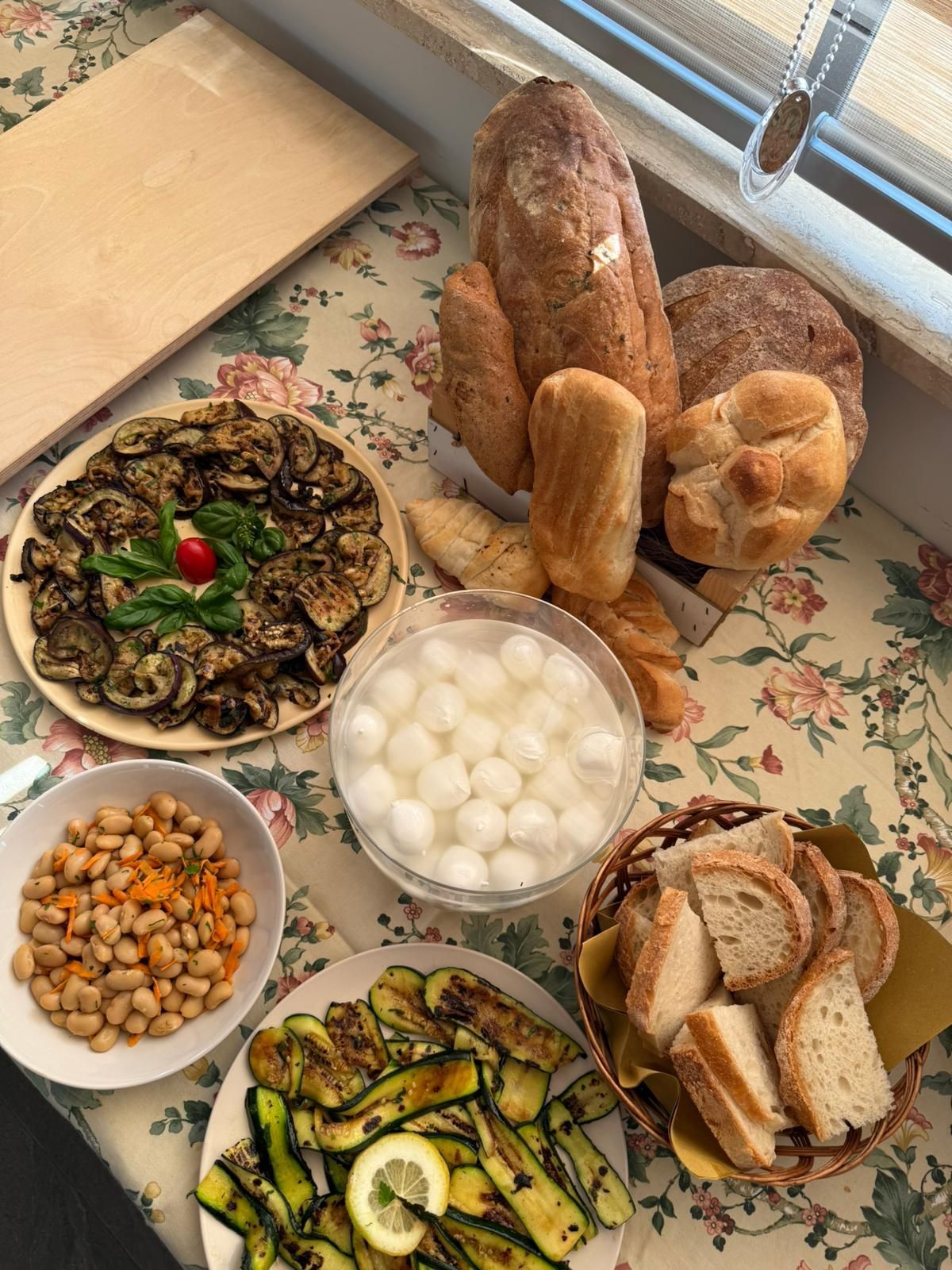 Tabella di vari alimenti, tra cui verdure grigliate, pane e ceci.