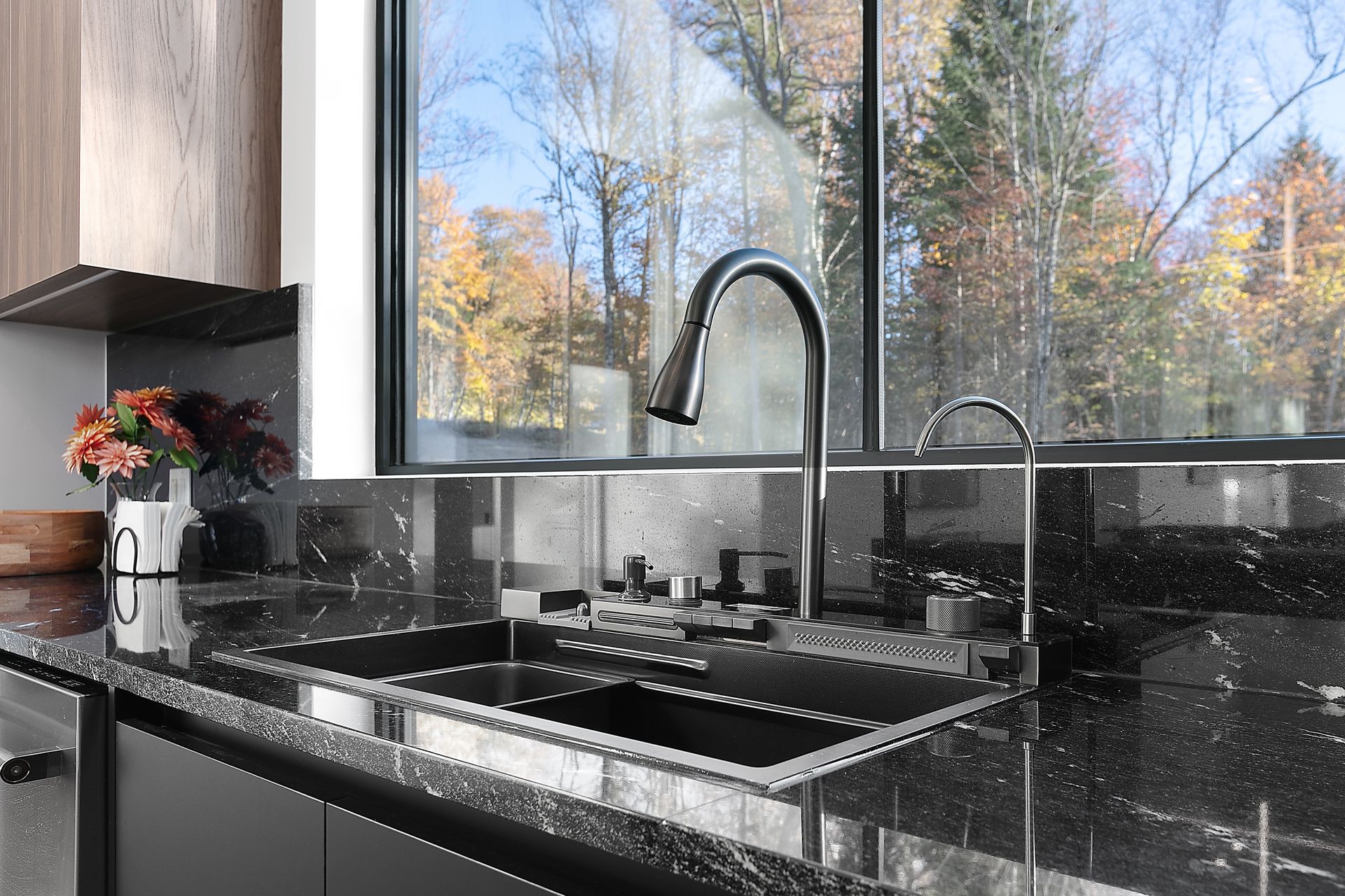 Évier de cuisine avec vue sur les couleurs d'automne par une grande fenêtre.