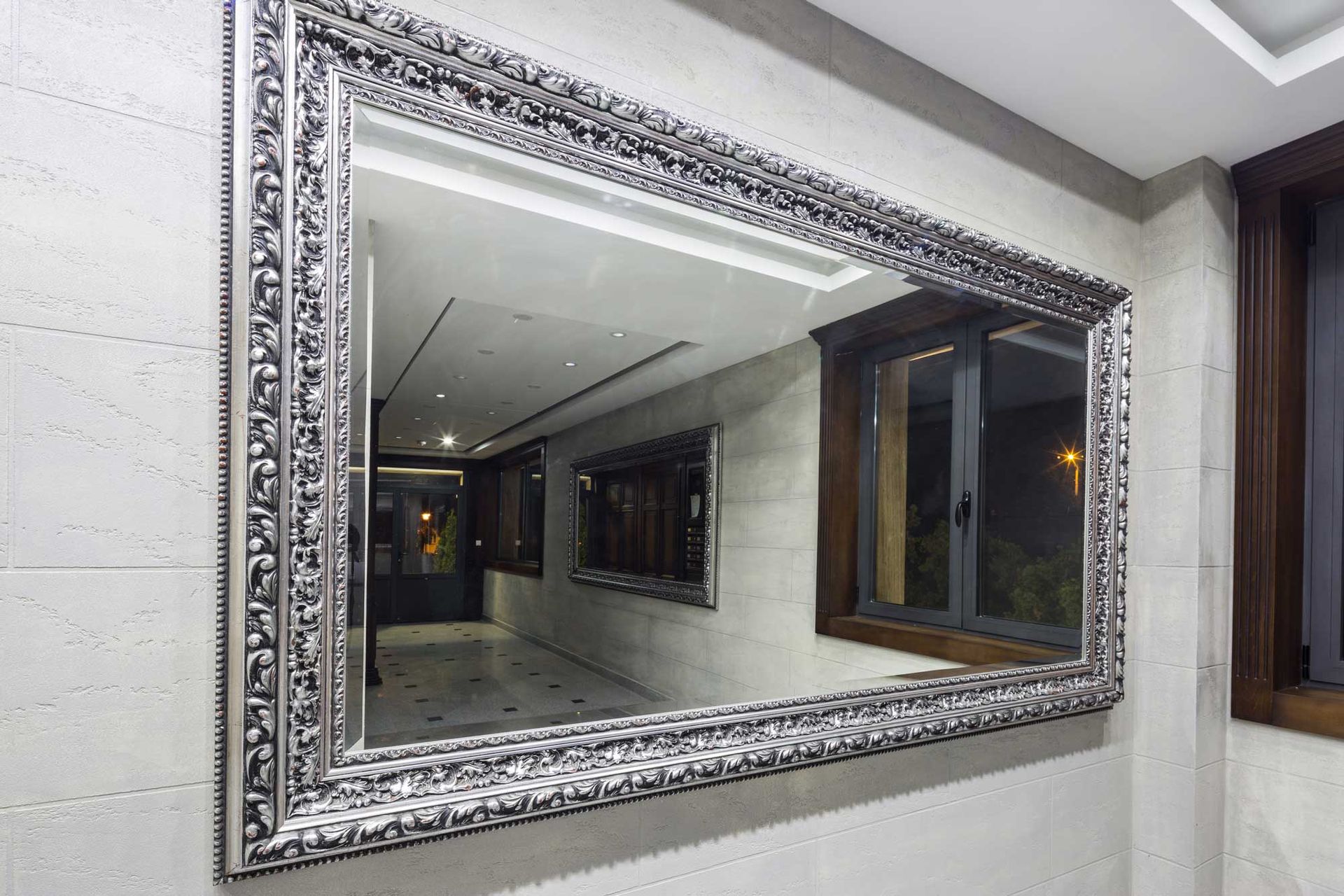 A large, ornate, silver-framed wall mirror showcases elegant mirrors for interior home decor.