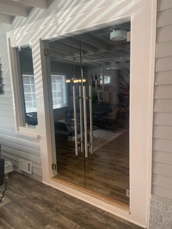 Glass double doors with silver handles, inside view of a home.