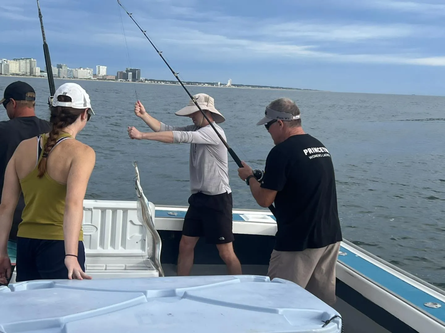 A group of people are fishing on a boat with the word fishing on the side
