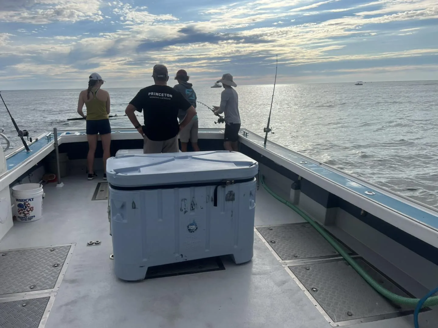 A group of people are fishing on a boat in the ocean.