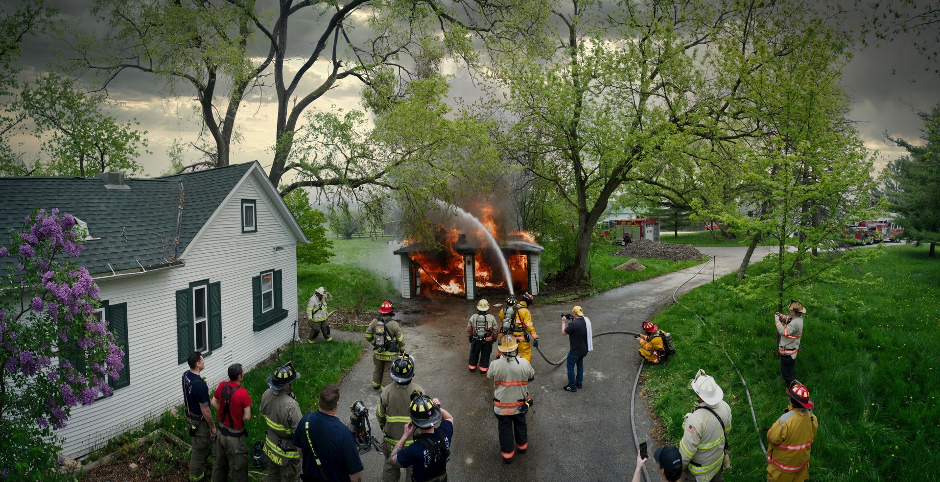 A group of firefighters are fighting a fire in a house.