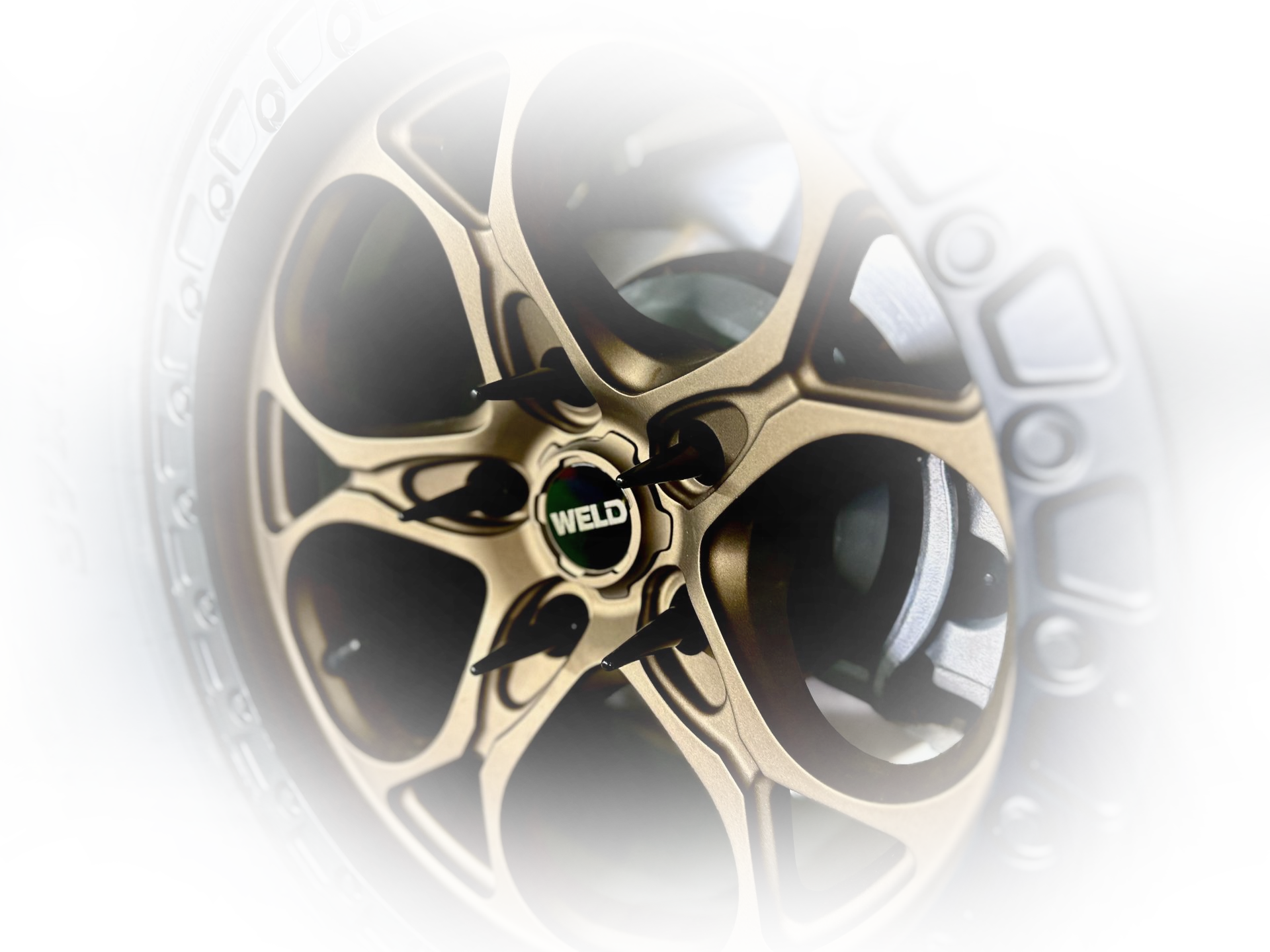 Gold and black WELD car wheel with multiple spokes.