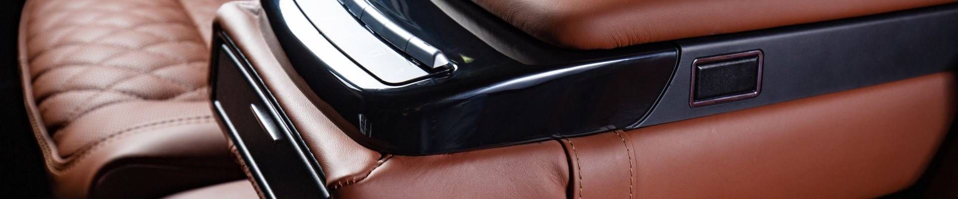 Black glasses resting on a brown leather surface.