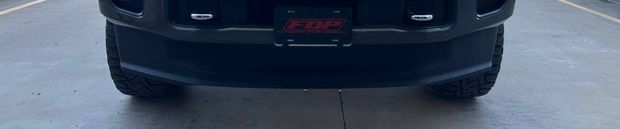 Rear view of a black truck with a license plate that has 