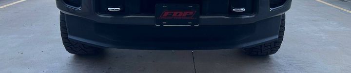 Rear view of a black truck with a license plate that has 