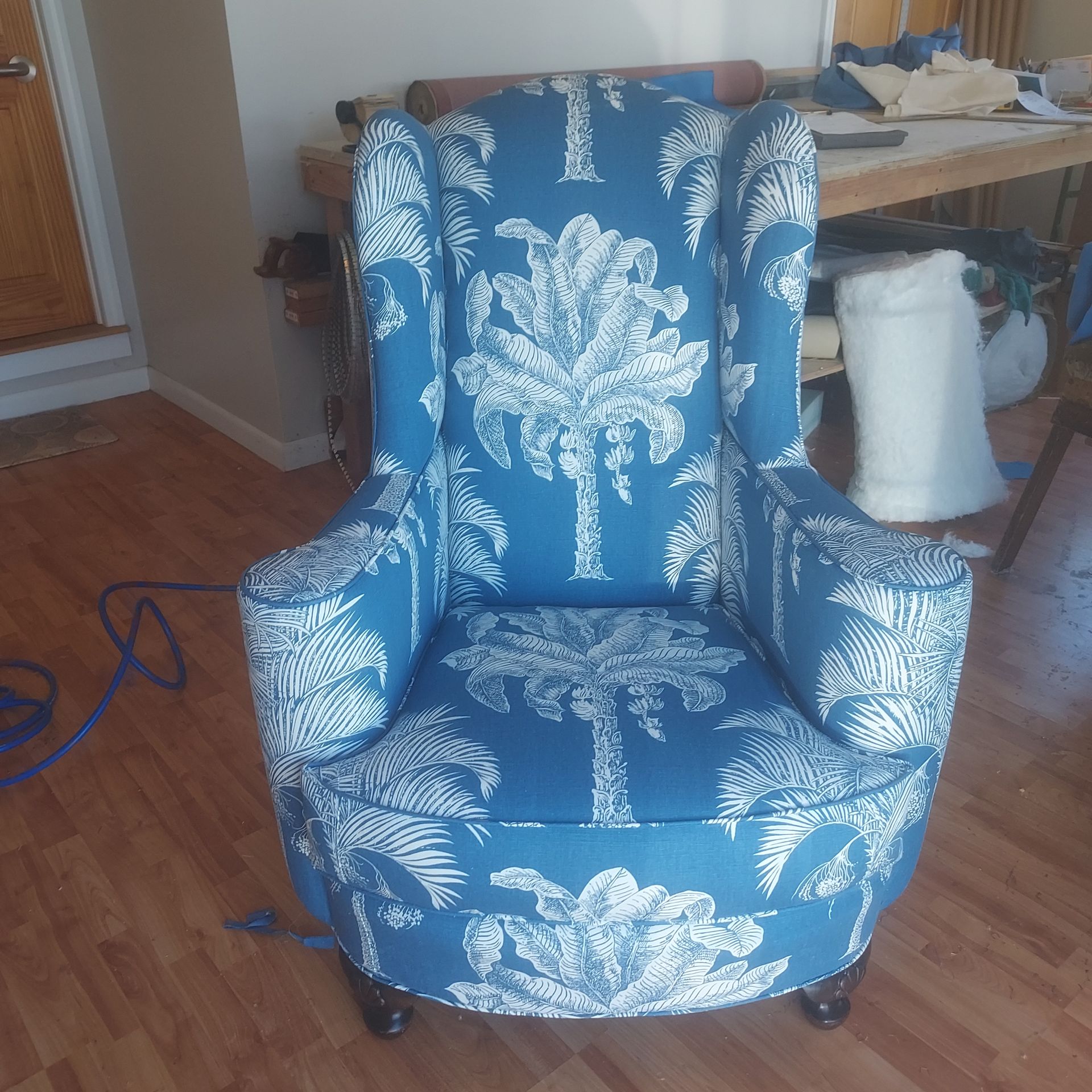 A blue and white chair with palm trees on it