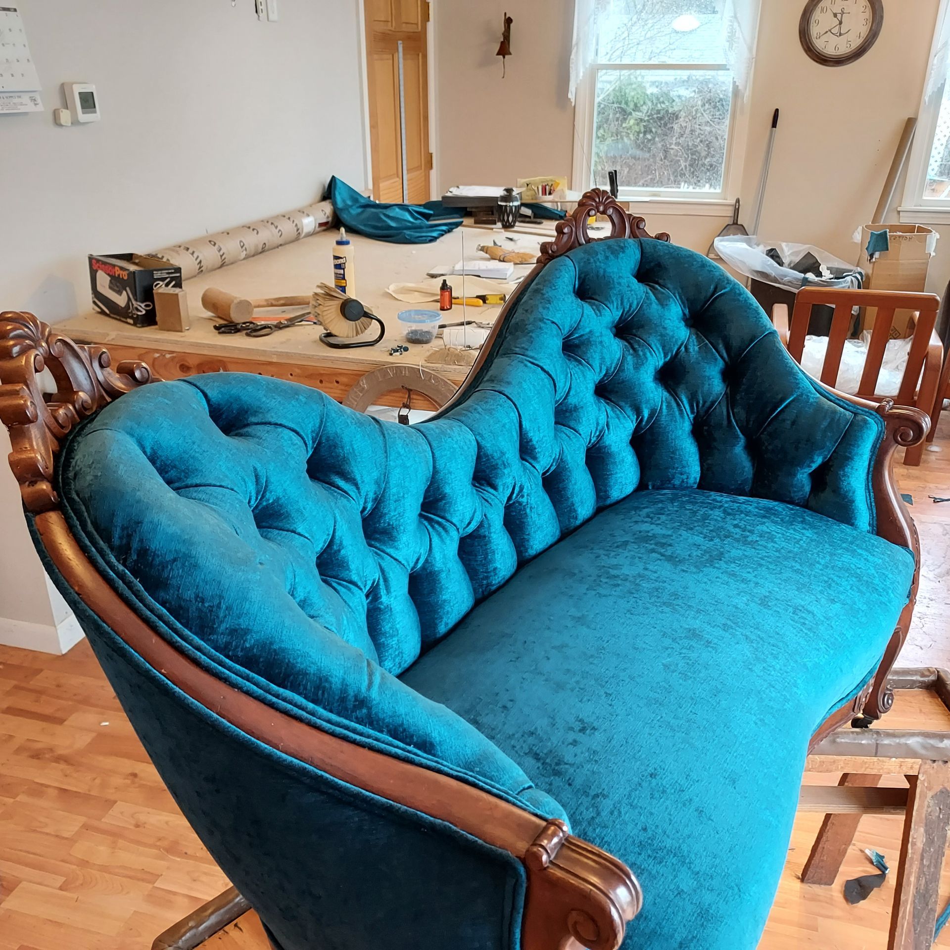A blue couch with a wooden frame is in a living room