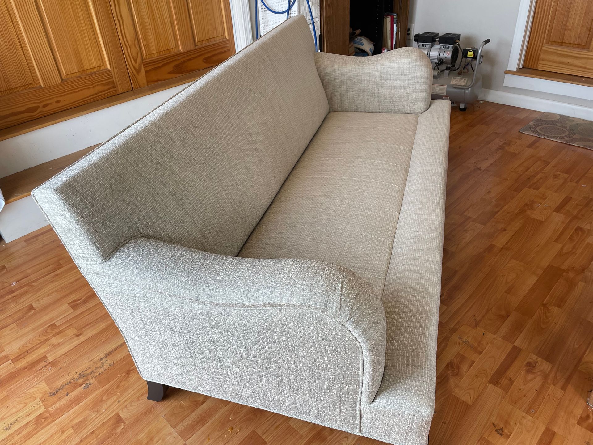 A white couch is sitting on a wooden floor in a living room.