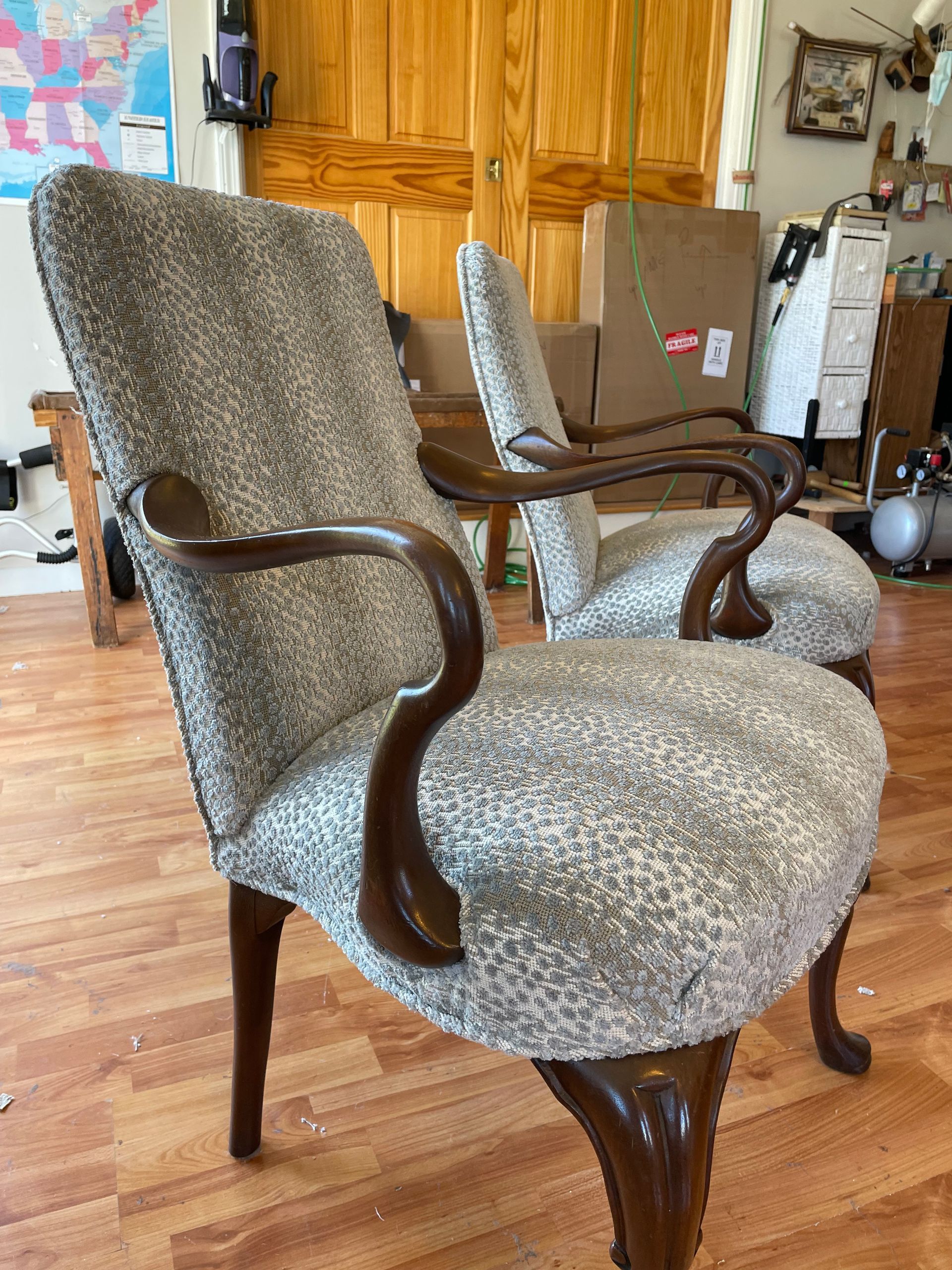 Two chairs are sitting on a wooden floor in a room.